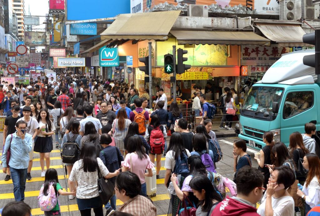 People walking across a busy traffic crossing.